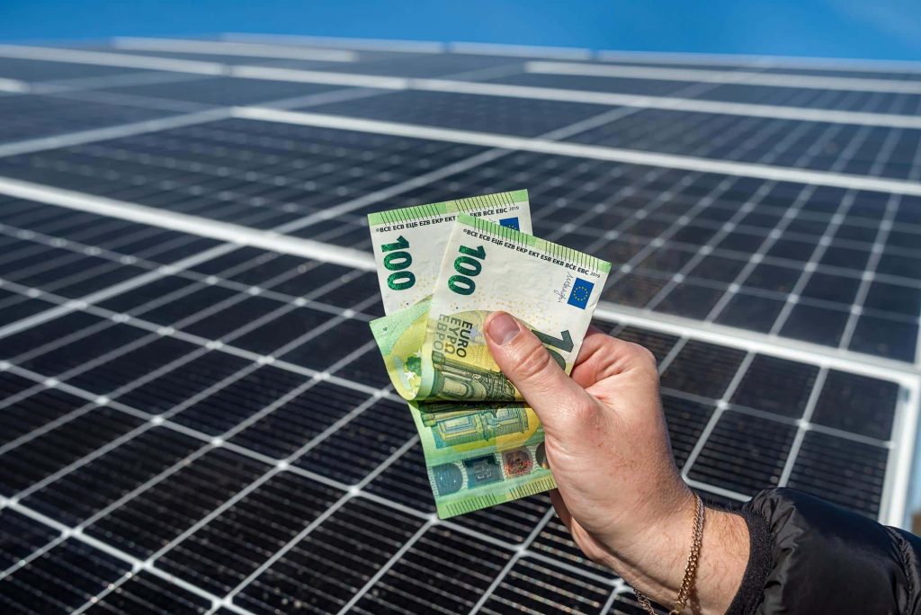 financement ombrieres solaires suneco - billets de banque devant panneaux solaires